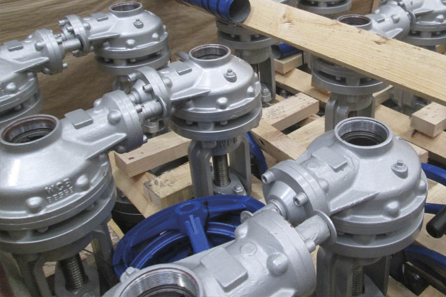 Valves for oil fields: A set of globe valves packed inside of a wooden container.